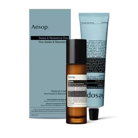 Eine Pumpflasche Solais Replenishing Hand Serum und eine Tube Reverence Aromatique Hand Balm zusammen in einem Karton