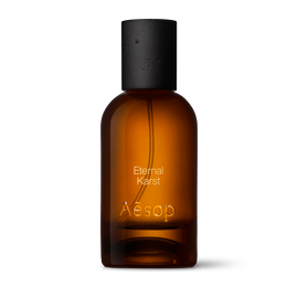 Bernsteinfarbene Flasche des Aesop Eternal Karst Eau de Parfum aus Glas mit schwarzem Verschluss vor weißem Hintergrund.